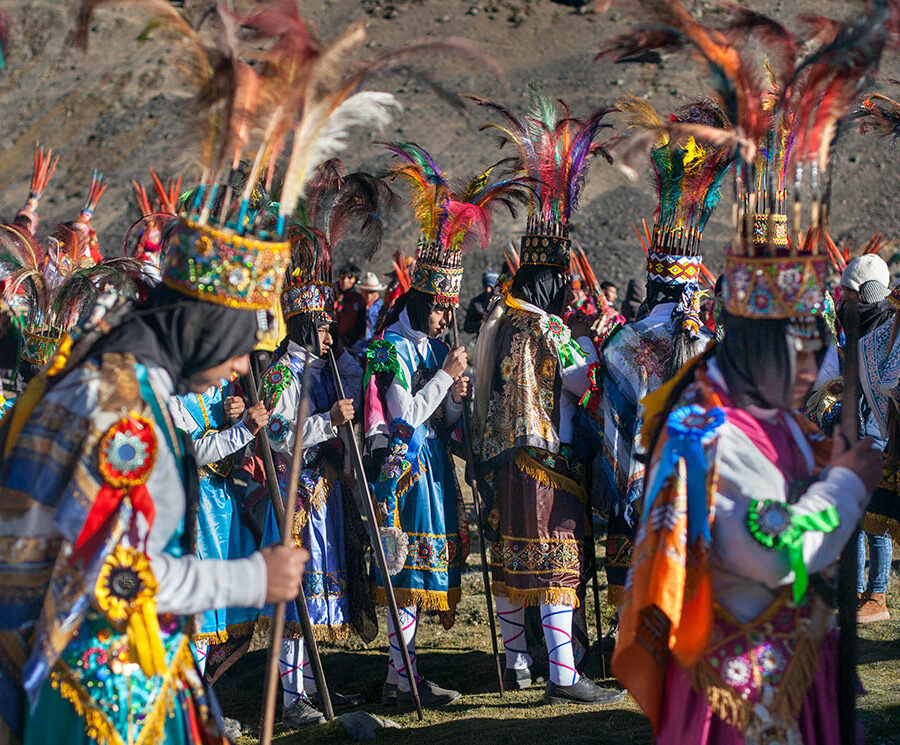 Comparsa de danzantes de vistiendo trajes coloridos y tocados de plumas, en la procesión del señor de Qoyllur Riti.