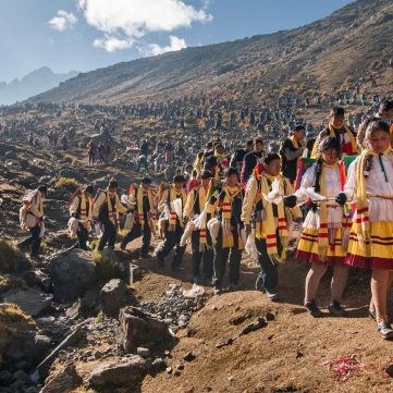 Comparsa de peregrinos bailando durante la festividad del Qoyllur Riti en los Andes de Cusco, Perú.